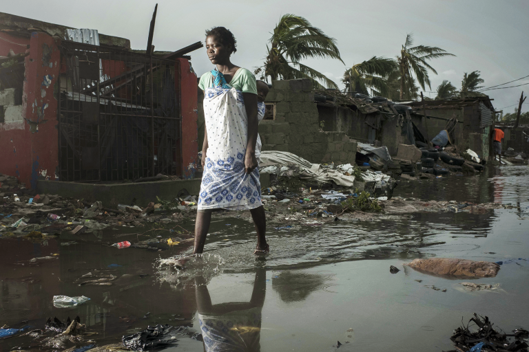 A woman walks through a flooded street in haiti.