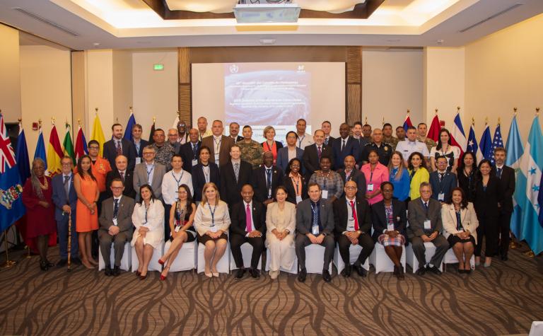 Group of delegates from various countries posing for a photo at an international conference.