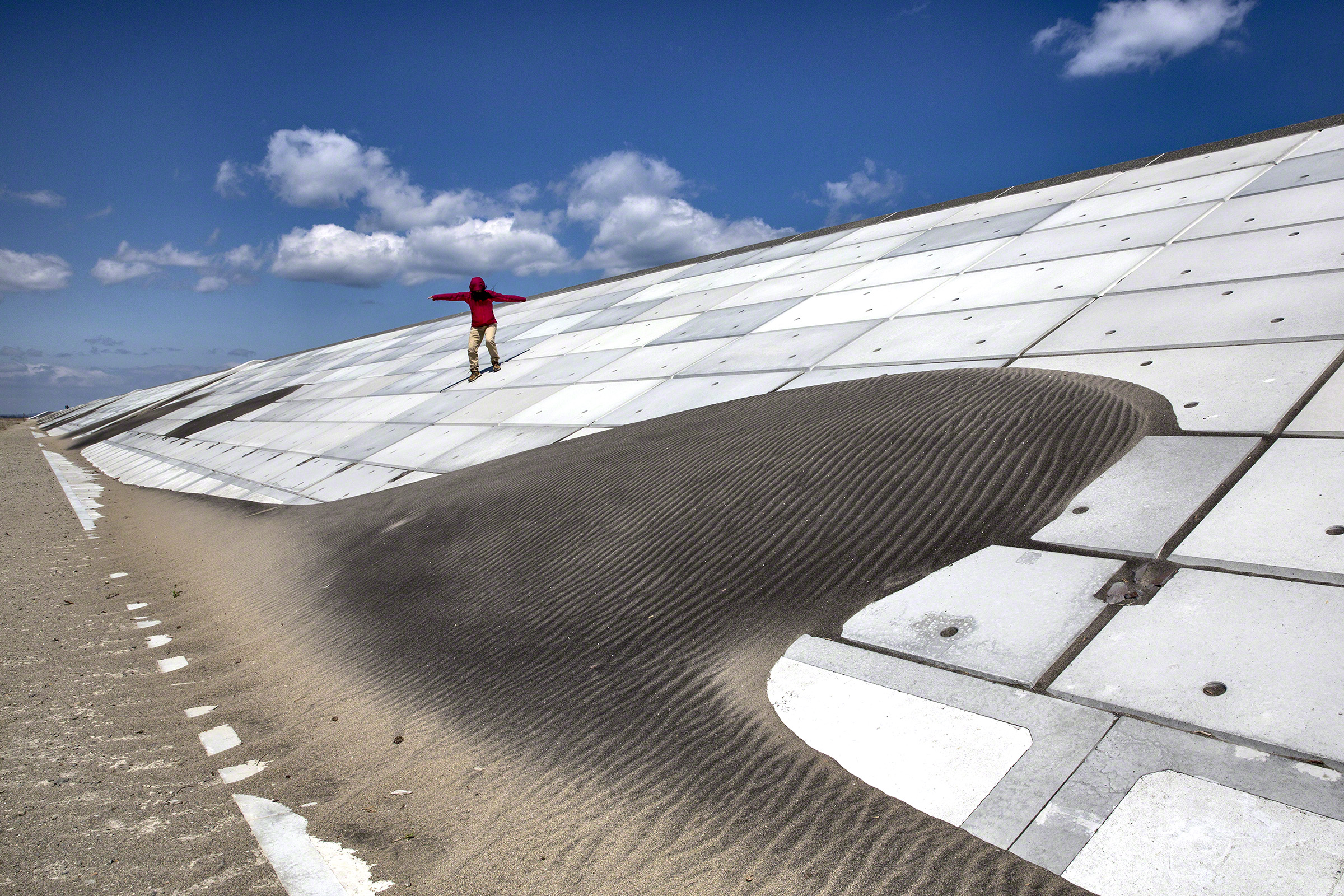 A woman makes her way down the seawall along the Kitakama and Ainokama coastline in Sendai, Japan. After the tsunami in 2011, the Japanese government has spent billions of yen on the reconstruction of a 31.8 km seawall along the Sendai coastline. Photo: P