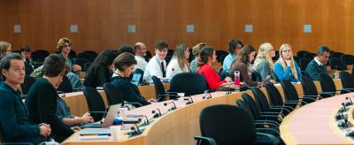 Attendees seated in a conference room listening to a speaker.