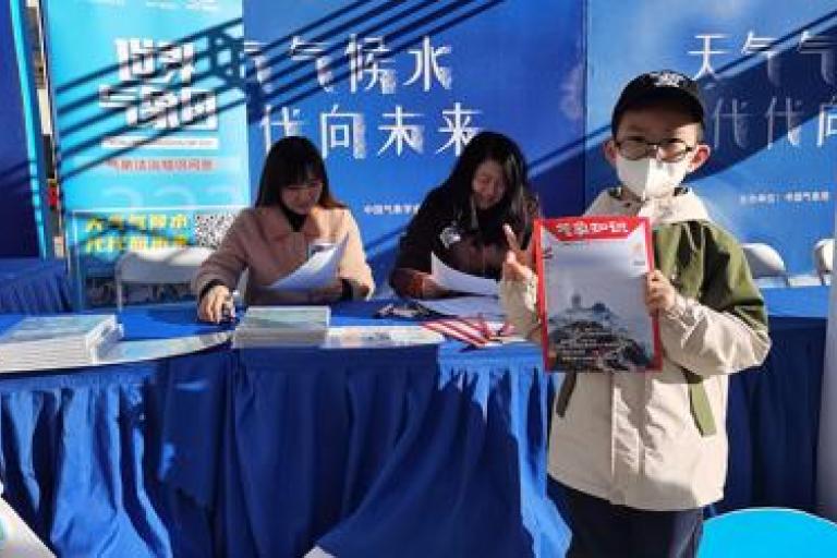 children received the magazine of Meteorological Knowledge in the park of CMA in Beijing. 