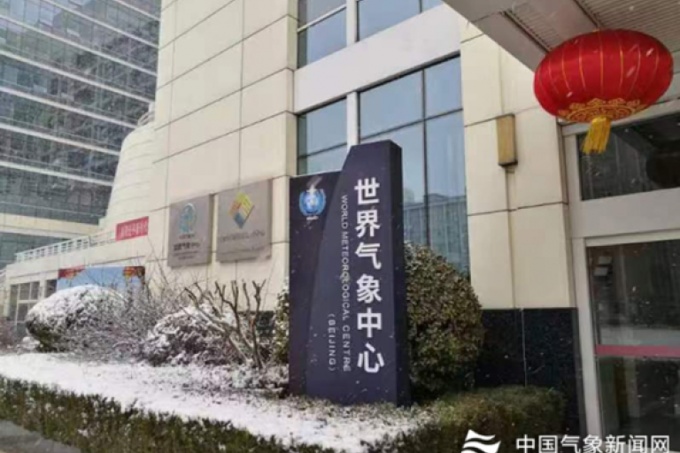 A snow covered building with a sign in front of it.