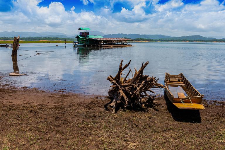 a boat docked on the shore of a lake.