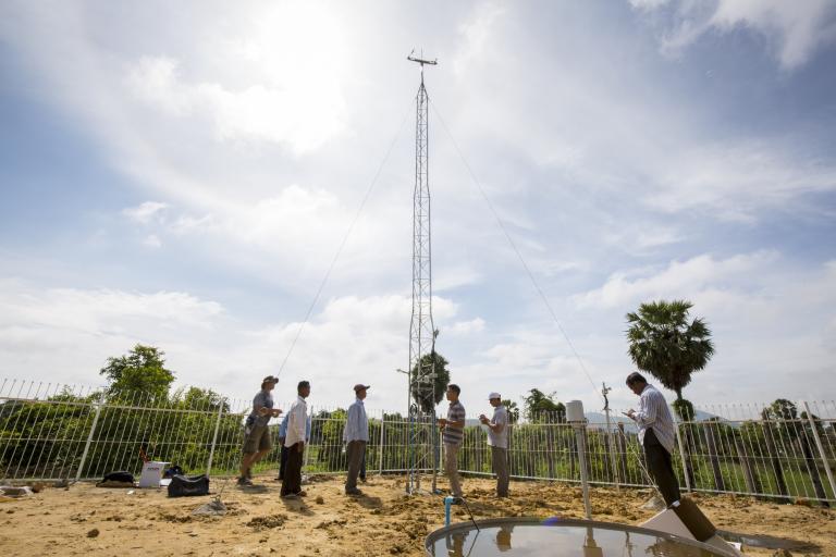 A group of people standing around a water tower.