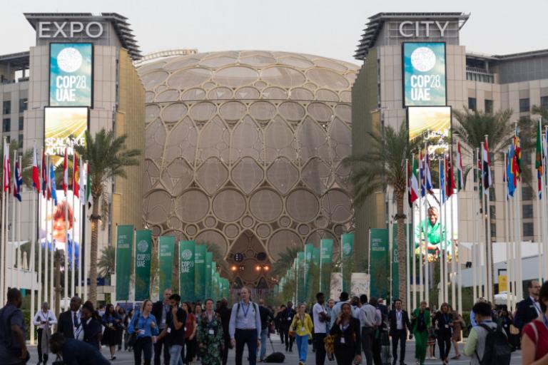 A group of people walking in front of a large building.