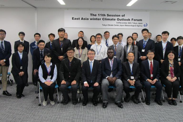 A group of people posing for a photo in a conference room.