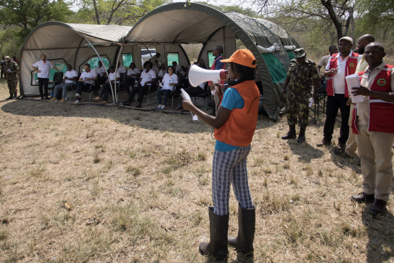 A group of people standing in front of tents.