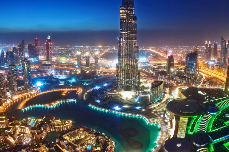 The burj khalifa tower is lit up at night.
