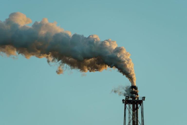 A smokestack with smoke coming out of it.