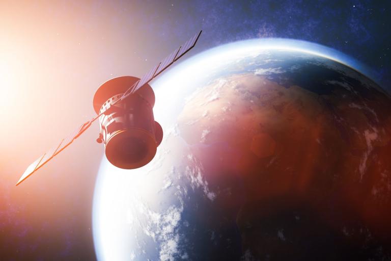 An image of a spacecraft flying over the earth.