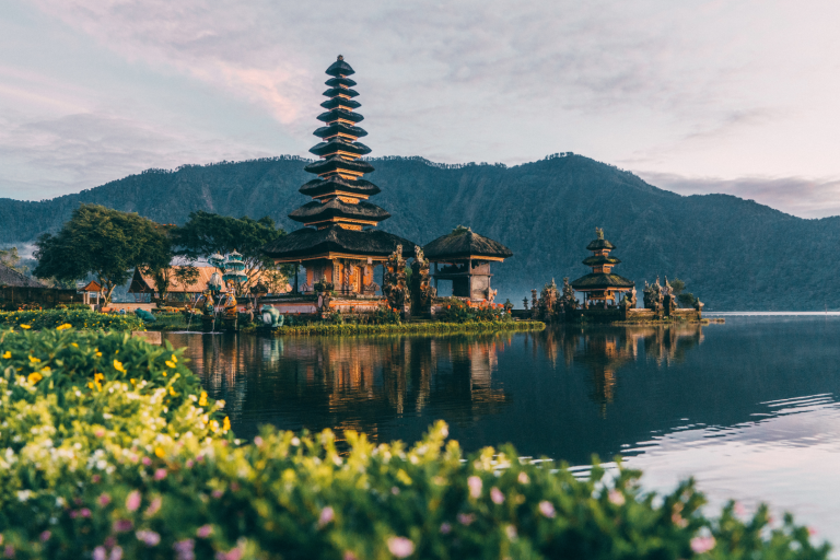 A building with a tall tower on the water.