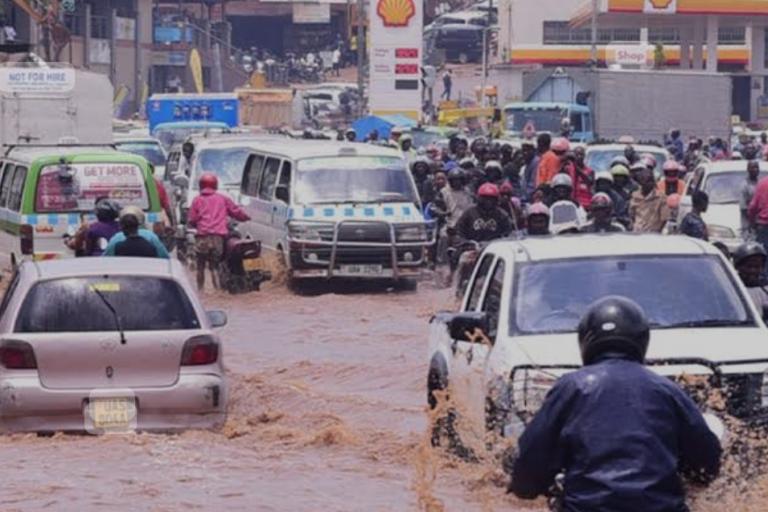 Traffic navigates through a flooded urban street.