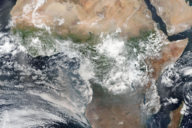 A satellite image of the African continent, showing diverse landscapes including deserts in the north, dense forests in central areas, and surrounding oceans.