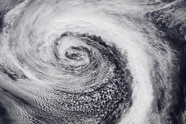 A satellite image of a large cyclone showing a swirling pattern of clouds over the ocean.