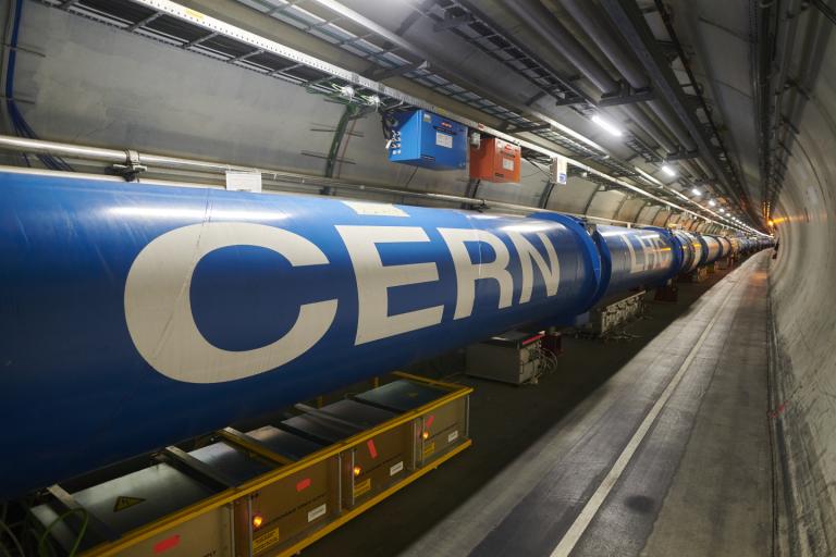 A long blue cylindrical structure in a tunnel with the word "CERN" written on it, part of the Large Hadron Collider.