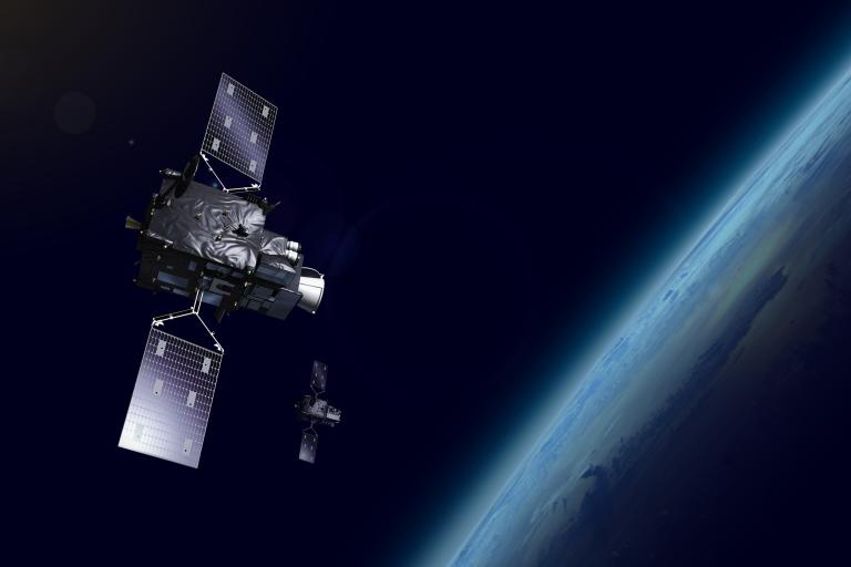 Two satellites orbit Earth in space, with part of the planet visible in the background.