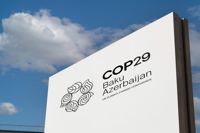 Sign for COP29 climate conference in Baku, Azerbaijan, featuring event logo against a clear blue sky.