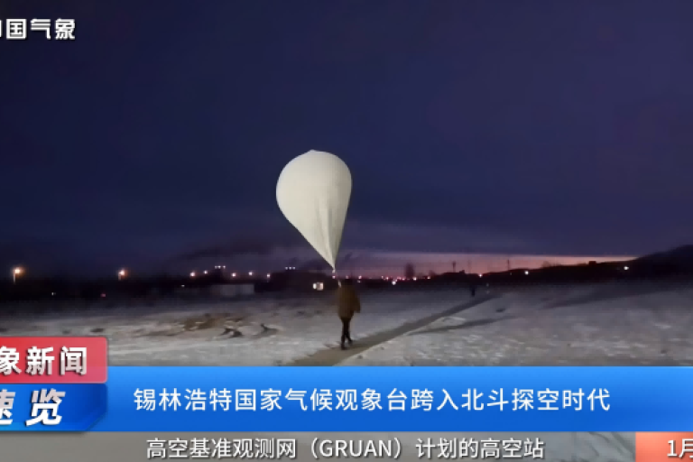 A person walks in snow holding a large weather balloon against a twilight sky. Chinese text is present at the top and bottom of the image.