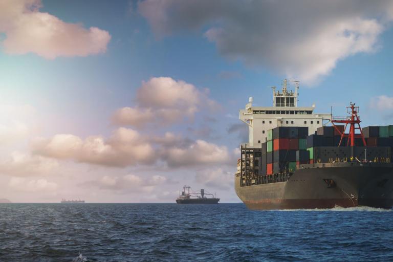 A massive cargo ship navigating the open sea, surrounded by water