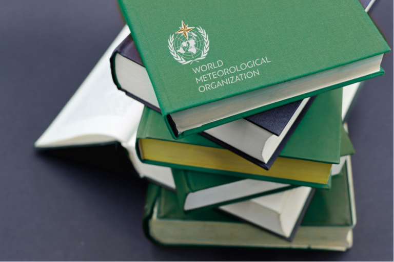 A stack of hardcover books, with the top book titled "World Meteorological Organization" and bearing its logo, set against a dark background.