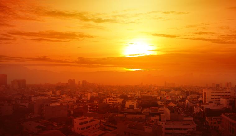 Heatwave on the city with the glowing sun background