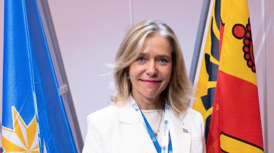 Celeste Saulo in front of the WMO  and Geneva Canton flags