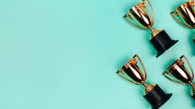 A group of gold trophies on a turquoise background.