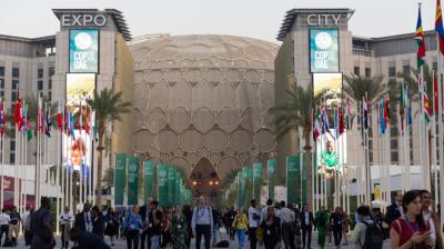 A group of people walking in front of a large building.