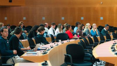 Attendees seated in a conference room listening to a speaker.
