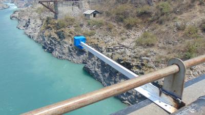 Simple water supply system using a suspended pipe over a river.