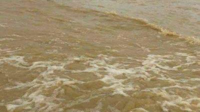 Floodwaters have inundated the fenced-off perimeter area of the Piarco Airport (Trinidad and Tobago), submerging it nearly up to the top of the chain-link fence, under an overcast sky.