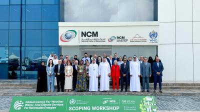 A group of people stands in front of the National Center of Meteorology (NCM) building, displaying a banner that reads "Global Centre for Weather, Water, And Climate Services for Renewable Energies Scoping Workshop.