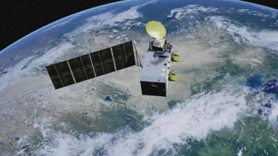 A satellite with solar panels orbits Earth, with a view of continents and clouds below.