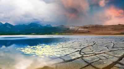 A split landscape shows a serene lake with mountains on the left and cracked, dry earth under a red sky on the right, illustrating a contrast between lush and arid environments.