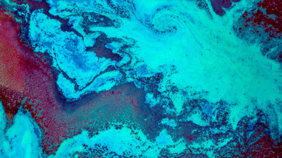 Abstract image featuring swirling patterns in blue, turquoise, and hints of red, resembling marbled textures or a view of Earth from space.
