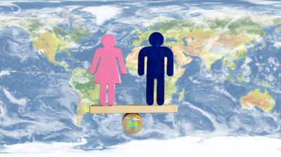 Pink female and blue male symbols stand balanced on a wooden plank over a globe, with a world map background, representing gender equality worldwide.
