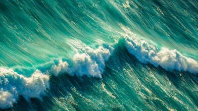 Aerial view of turquoise ocean waves crashing with white foamy crests.
