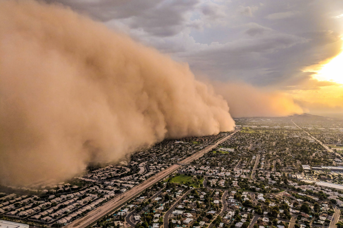 A huge cloud of sand blows over a city.