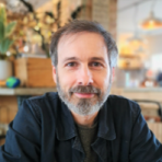 A man with a beard sitting at a table.