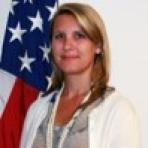 A woman standing in front of an american flag.