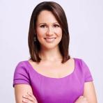 A woman in a purple dress posing for a photo.