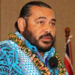 A man in a hawaiian shirt speaking into a microphone.