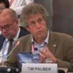 A man sitting at a table with a microphone in front of him.