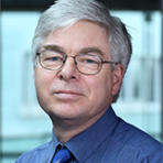 A man wearing glasses and a blue tie.