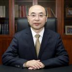 A man in a suit and tie sitting at a desk.