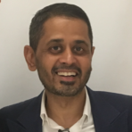 A man in a suit smiles for the camera.