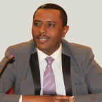 A man in a suit and tie sitting at a desk.