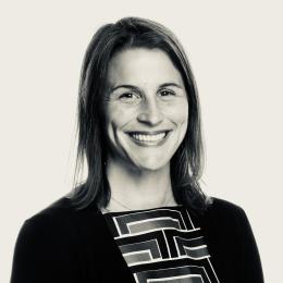 A black and white photo of a smiling woman.