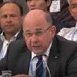 A man in a suit and tie sitting at a table.
