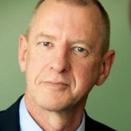 A close up of a man in a suit and tie.